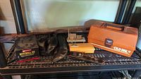 Photo showing Mitchell 300 spinning reel in original box with promotional insert, small black tackle box, leather case for cutting utensil, and large orange Old Pal tackle box along with wooden fishing wharf model.