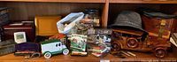 Photo of shelf showing wood model car, jars and boxes of matchbooks, hats and collectible items.