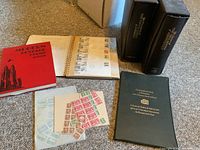 Overview of four stamp albums and loose stamps scattered on floor