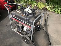 Side view of portable generator showing steel frame, fuel tank, wheels and coiled power cable on top