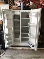 Interior view of empty white Whirlpool refrigerator freezer showing shelves, door bins, and compartments.