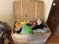 Open wicker basket filled with stuffed animals and toys.