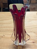 Front perspective of ruby red cased art glass vase showing the swung petal rim and clear glass outer ruffles.