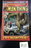 Front cover of the 1972 Marvel comic book Adventure Into Fear #10 showing The Man-Thing holding a child with two men aiming guns in swamp background. Shows minor wear but no tears or marks.