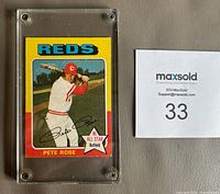 Front of 1975 Pete Rose baseball card #320 showing Pete Rose in a batting stance, with team name 'REDS' and NL All Star designation, encased in plastic holder.