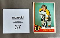 Front of Bobby Orr 1974-75 O.P.C. hockey card, color image with Bruins uniform and red border.