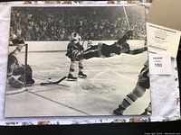 Full view of the laminated 16 x 20 photo laid flat with COA and sticker present