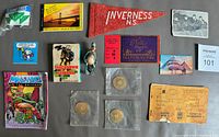14 vintage items laid out on grey surface showing ration book, tokens in plastic sleeves, pennant, football card game, and various tickets.