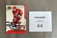 Front view of Steve Yzerman autographed 2002-03 Calder hockey card positioned beside sale number card