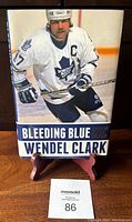 Front cover of the 2016 hardcover autobiography "Bleeding Blue" by Wendel Clark showing him in Toronto Maple Leafs uniform.
