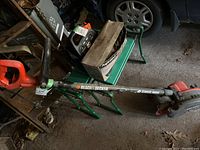 Full side view of Black & Decker edger showing metal handle, black and red motor housing, and wheels.