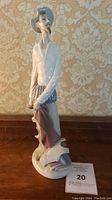 Full view of the 12-inch Lladro Don Quixote porcelain figurine on a wooden surface with decorative wallpaper background.