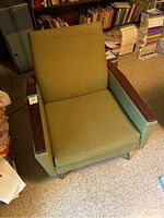 Front view of the vintage olive green cocktail lounge chair showing wooden armrests and fabric upholstery.