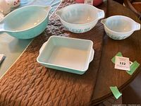 Overhead view of all three round mixing bowls and rectangular baking dish showing turquoise exteriors and white interiors
