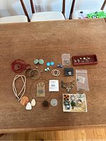 Full layout of jewelry including bracelets, earrings, pins, and charms on a wooden table
