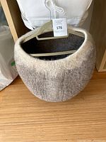 Front view of the natural ombre felted wool cat cave on a wooden floor.