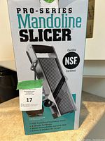 Front view of the product box showing Pro-Series Mandoline Slicer branding, NSF certification, and key features.