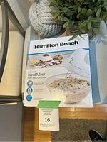 Front view of the Hamilton Beach hand mixer box showing product image and branding.
