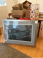 Front view of framed print showing two loons on water with rocky background