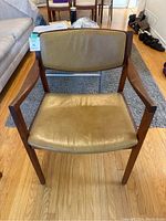 Front view showing leather seat and back within wood frame