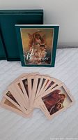 Photo showing boxed green gift box, Angel Blessings guidebook, and a fanned display of the oracle cards with angel art reproductions.