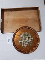 Top-down photo showing both the rectangular wooden pastry board and round copper tray with floral design.