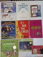 Top view of nine children's books in assorted condition including classic titles like 'The Snowman' and 'If I Ran the Circus'. Colorful covers with illustrated animals and characters.