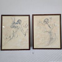 Two framed prints side by side showing black ink drawings of angels by il Guercino in wood frames with glass.