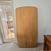 Front view of solid oiled oak rectangular table top with slightly rounded edges showing wood grain.