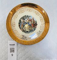 Full view of the Sabin Crest-O-Gold plate showing the gold-plated border with filigree and the hand-painted scene of a courting couple in the center