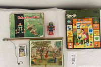 Photo of Fishing Game Blocks box with rod, vintage wooden jigsaw puzzle box with children playing in garden scene, red plastic wind-up robot and Galt Toys Find It game box