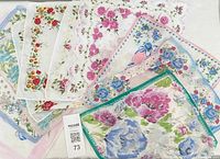 Photo shows ten vintage floral printed handkerchiefs laid overlapping to display various floral designs and colors, including pink, blue, red, and green. The handkerchiefs have different scalloped and straight edges with multi-color floral patterns.