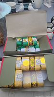 Box of individually wrapped green and yellow soaps, open showing contents