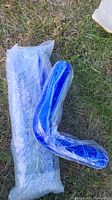 Photo of two blue coolant hoses on grass, one L-shaped and one straight, both wrapped in bubble wrap.