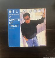 Front cover of the Billy Joel vinyl record maxi single 'A Matter Of Trust' showing the artist and title on the sleeve.