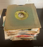 Stack of 7 inch singles with Beatles 'Get Back' single on top in a paper sleeve, showing the collection and condition of sleeves.
