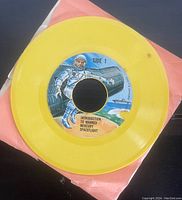 Photo of Side 1 of yellow vinyl record with label showing astronaut and space capsule, title 'Introduction to Manned Mercury Spaceflight'