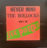 Front cover of the vintage Sex Pistols 'Never Mind The Bollocks' vinyl LP album showing vibrant orange and green colors with bold text.