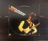 Front cover of 'Fly Like An Eagle' vinyl record by Steve Miller Band showing the title and an image of a guitarist in action, vintage original album cover.