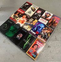 Photo showing all 15 VHS tapes laid out on a floor surface.