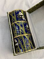 Cloisonné panda and bamboo pen holder inside patterned gift box, showing detail of pandas and bamboo branches