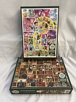 Two 1000-piece Cobble Hill puzzles showing box art, one with colorful cat illustrations and the other with bookshelf and cats, placed on a white surface.