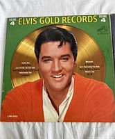 Front of album sleeve with Elvis Presley's photo, gold record, track listing, and RCA Victor logo.