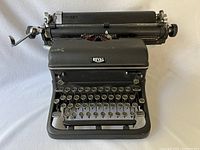 Front view of a black Royal typewriter showing the keys, carriage return lever, and brand logo.