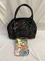 Two bags shown together on white background: black Aritzia tna duffle bag with multicolored logos and colorful patchwork Coach handbag in front.