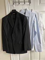 Black pinstripe suit jacket hung with two shirts behind it, showing the overall set for sale including jackets and shirts hung on a door.