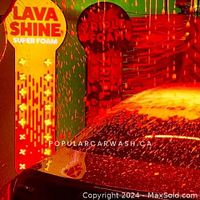Car being washed with Lava Shine Super Foam in bright red and yellow foam dispensers with water spraying.