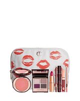 View of all 7 makeup products displayed standing with compact and sticks open, showing full product design and packaging along with branded makeup bag with lip prints.