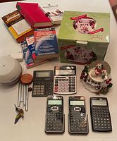 Photo showing entire lot together including calculators, books, wind chime, diffuser and snow globe.