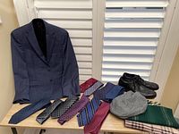 Blue men's blazer jacket size 38R, black Rockport lace-up shoes size 9W, assortment of colorful men's ties, London Fog men's cap size L with tags, and two scarves displayed on table and hanging.